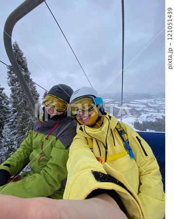 Skiers on Lift with Snowy Mountain View 121051439
