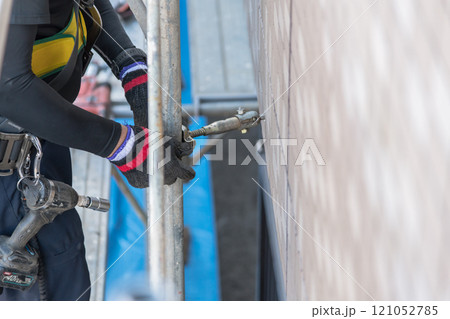 【マンション大規模修繕工事　壁つなぎを接続し足場を作る作業員】     121052785
