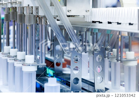 robot arm moving plastic bottle to conveyor belt of auto capping and labeling machine at cosmetic and skin care manufacturing. cosmetic industry and ai technology machinery concept. robot arm moving plastic bottle to conveyor belt of auto capping and labeling machine at cosmetic and skin care manufacturing. cosmetic industry and ai technology machinery concept. 121053342