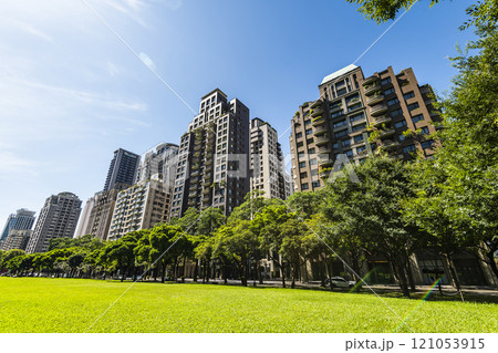 Low-angle view of green park space and modern buildings on both sides in downtown Taichung, Taiwan, It is near the National Taichung Theater. 121053915