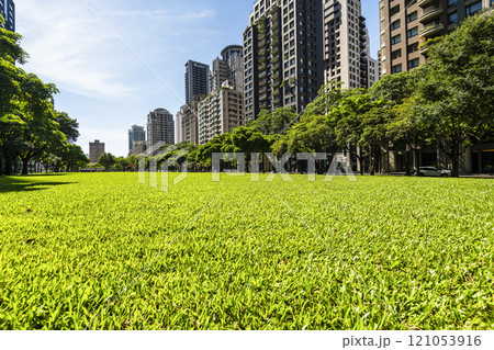 Low-angle view of green park space and modern buildings on both sides in downtown Taichung, Taiwan, It is near the National Taichung Theater. 121053916