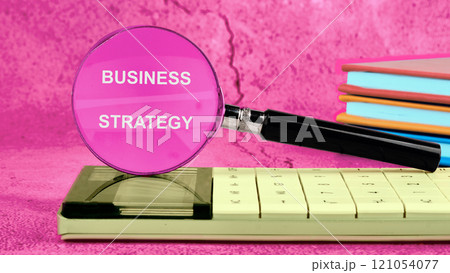 Business planning concept. BUSINESS STRATEGY written on the glass of the magnifying glass Business planning concept. BUSINESS STRATEGY written on the glass of the magnifying glass 121054077