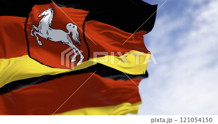Lower Saxony state flag waving with German flag on a clear day Lower Saxony state flag waving with German flag on a clear day 121054150