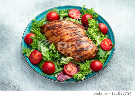 Grilled chicken breast ( fillet ) with lattuce salad and cherry tomatoes . Top view Grilled chicken breast ( fillet ) with lattuce salad and cherry tomatoes . Top view 121055754