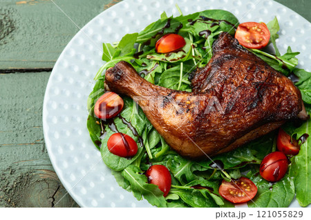 Grilled chicken legs with tomatoes and salad . Top view Grilled chicken legs with tomatoes and salad . Top view 121055829
