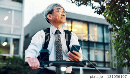 Businessman, phone or electrical bike for urban travel, clean energy or sustainable transport. Thinking, mature and eco friendly bicycle with mobile app for location, city commute or map in Japan Businessman, phone or electrical bike for urban travel, clean energy or sustainable transport. Thinking, mature and eco friendly bicycle with mobile app for location, city commute or map in Japan 121056107
