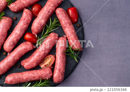 Raw beef sausages with rosemary and tomatoes photography . Top view 121056166