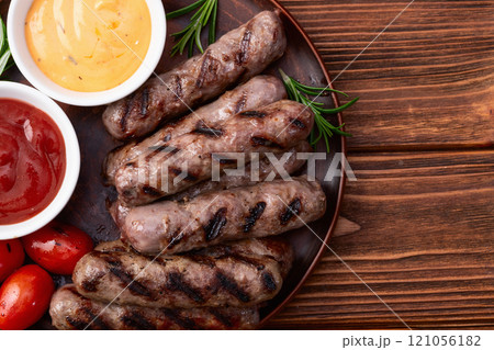 Grilled beef sausages with rosemary sauce and tomatoes photography . Top view 121056182