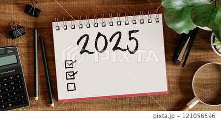 2025 checklist notebook with office supplies on desk, 3D render. 121056596