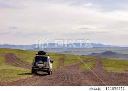 Japanese SUV on a dirt mongolian road in mountains 121059252