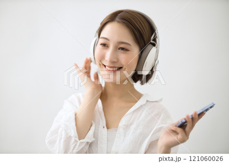 ヘッドフォンで音楽を聴く若い女性 ヘッドフォンで音楽を聴く若い女性 121060026