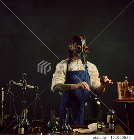 Doctor, carefully measuring herb into large jar,appears to be creating tincture or infusion, surrounded by classic laboratory tools. Doctor, carefully measuring herb into large jar,appears to be creating tincture or infusion, surrounded by classic laboratory tools. 121060689