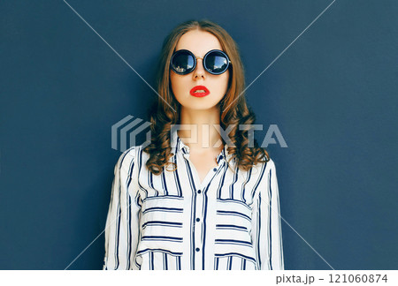 Fashion portrait elegant woman in a black sunglasses posing over a gray background Fashion portrait elegant woman in a black sunglasses posing over a gray background 121060874