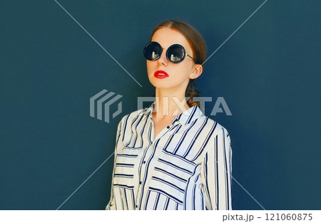Fashion portrait of elegant woman lady wearing a black sunglasses posing over a gray background 121060875