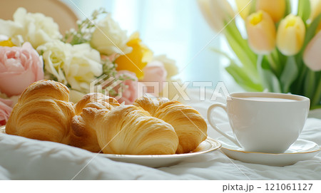 A cozy breakfast in bed with croissants and coffee, surrounded by fresh flowers and morning light A cozy breakfast in bed with croissants and coffee, surrounded by fresh flowers and morning light 121061127
