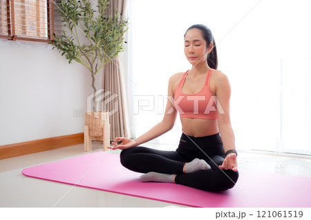 Young asian woman meditation sitting on mat in serene and tranquility with yoga posture lotus. 121061519