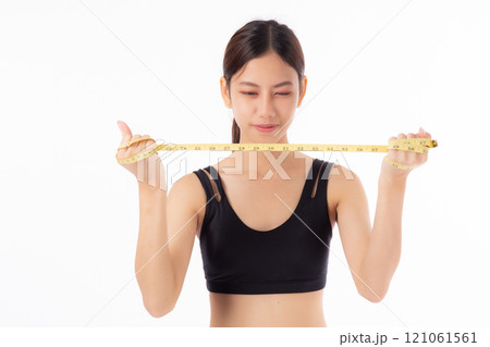 Portrait happy young asian woman in sportswear holding measure tape isolated white background. 121061561