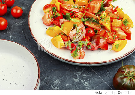 Fresh salad preparation with tomatoes and greens. 121063116