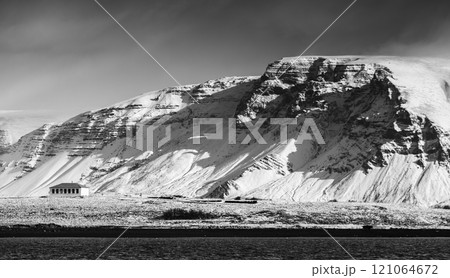Landscape with snowy coastal mountains under dark dramatic sky 121064672