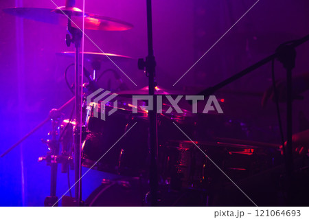 A rock drum set with cymbals in purple stage lights. Closeup photo A rock drum set with cymbals in purple stage lights. Closeup photo 121064693