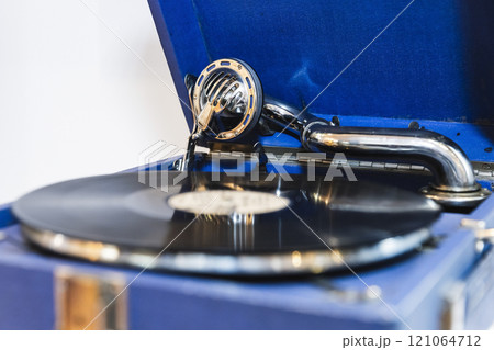 Blue vintage phonograph with black vinyl record plays an old music 121064712