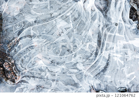 Abstract pattern of thin ice is on frozen puddle, natural background Abstract pattern of thin ice is on frozen puddle, natural background 121064762