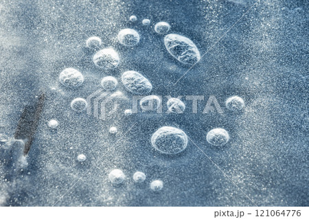 Frozen bubbles are under thin ice layer on a frozen lake 121064776