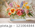 透明なガラスかアクリルのスクエアな花瓶に生けてあるビビッドカラーのかわいい草花 121064844