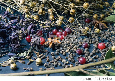 various spices scattered on a dark background with bunches of grass, laurel leaves, berries and other spices for cooking fragrant Eastern and Midwestern food. High quality photo 121065188