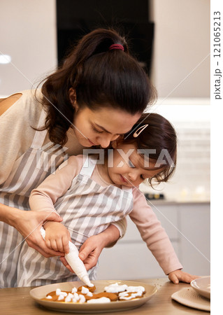 happy mother and little child girl bake cookies on the kitchen at home happy mother and little child girl bake cookies on the kitchen at home 121065213