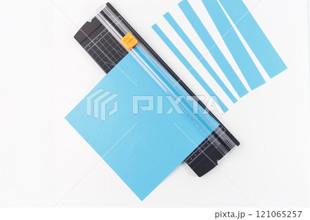 demonstrates the use of a paper trimmer, which is a common tool for precise cutting in crafting, demonstrates the use of a paper trimmer, which is a common tool for precise cutting in crafting, 121065257