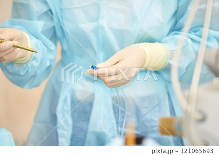 Healthcare professional in medical scrubs prepares equipment. Surgical procedure 121065693