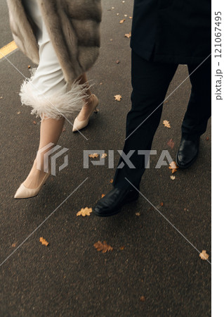 A bride and groom are joyfully walking down the street together 121067495