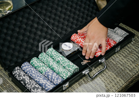 A person carefully places poker chips into a briefcase for safekeeping A person carefully places poker chips into a briefcase for safekeeping 121067503
