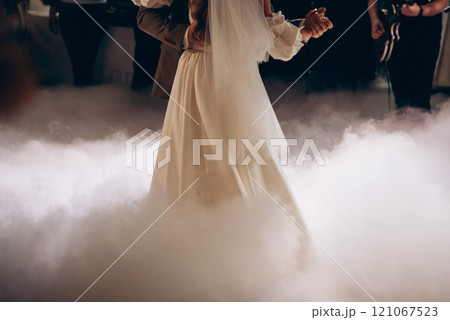 A bride and groom dance in the fog at their wedding reception A bride and groom dance in the fog at their wedding reception 121067523