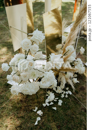 White flowers sit on the ground in front of a mirror 121067555