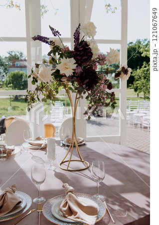 A wedding reception table set with a vase of flowers A wedding reception table set with a vase of flowers 121067649