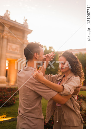Couple dancing salsa or swing in front of puerta de alcala in madrid at sunset Couple dancing salsa or swing in front of puerta de alcala in madrid at sunset 121067714