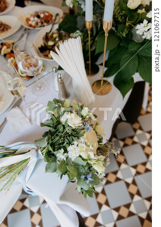 A decorated table with a stunning flower bouquet and elegant candles 121067715