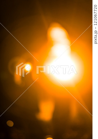 Blurred bright lights creating warm orange glow 121067720