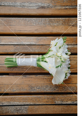 A lovely bouquet of white flowers is beautifully sitting on a wooden table A lovely bouquet of white flowers is beautifully sitting on a wooden table 121067886