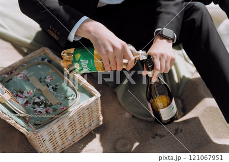 A welldressed man wearing a suit is skillfully opening a bottle of champagne A welldressed man wearing a suit is skillfully opening a bottle of champagne 121067951
