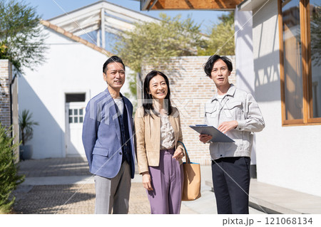 リフォームの打ち合わせをするビジネスマンとミドル夫婦 121068134