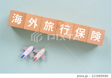 海外旅行保険の文字が入ったブロックと飛行機 121069480