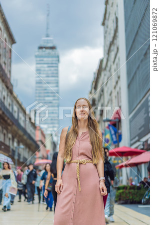 Female tourist exploring Latin American Tower in Mexico City. Iconic skyscraper, historic architecture, and urban exploration concept Female tourist exploring Latin American Tower in Mexico City. Iconic skyscraper, historic architecture, and urban exploration concept 121069872