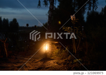 A Serene Evening Scene Featuring a Lantern and a Beautiful Flower in the Twilight Sky 121069973