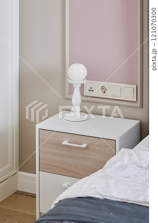 A Modern Nightstand Featuring a Stylish Lamp and Convenient Wall Outlet for Your Bedroom 121070300