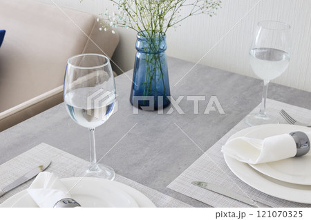 An Elegant Dining Table Setting Complete with Fresh Flowers and Modern Stylish Decor An Elegant Dining Table Setting Complete with Fresh Flowers and Modern Stylish Decor 121070325