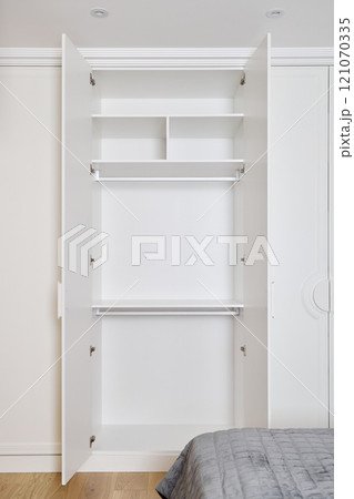 A Stylish and Modern Minimalist Wardrobe Featuring Organized Shelves and a Hanging Rod A Stylish and Modern Minimalist Wardrobe Featuring Organized Shelves and a Hanging Rod 121070335