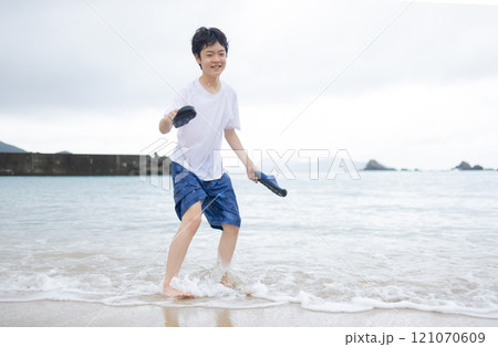 海辺で遊ぶ小学生男子 121070609